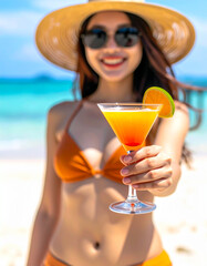 summer cocktail held in the hand of a young woman in a bikini on the beach
