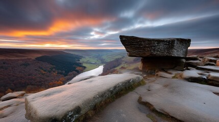 Dramatic landscape featuring balanced rocks at dawn, overlooking a valley