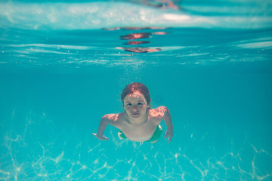 Kid boy swim underwater in summer pool. Summer kids vacation concept. Funny kids face underwater. Child splashing in swimming pool. Summer water sport. Summer vacation with child. - Powered by Adobe