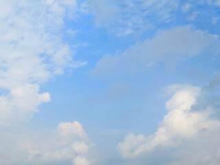 Blue sky background with white clouds in summer. Soft white clouds float in the clear blue sky. Clear blue sky, bright spring, soft sky gradient, wallpaper landscape, aerial view.