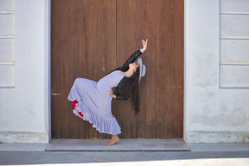 Young woman, beautiful, brunette, flamenco dancer, wearing a beautiful dress with jacket and hat,...