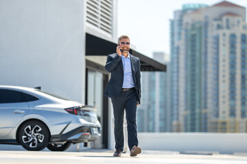 Successful business man walk talk on phone outdoors. Businessman call phone outside. Mature...