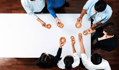 A diverse team of professionals collaborates on project management strategies by interacting with...