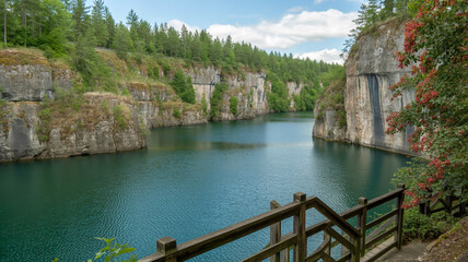Fototapeta premium A scenic photograph of a quarry lake surrounded by tall limestone cliffs.
