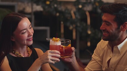 Smiling beautiful woman making a toast with Paloma cocktail to smart couple in Old fashioned savoring tasty enjoy drinking in lively conversation at bar refreshing special nightclub party. Vinosity.