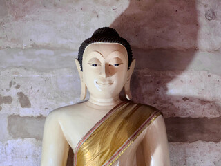 White Buddha statue on old wall grange background, Buddhism religion
