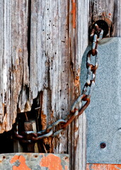 A rusty chain securing a wooden structure.