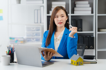 Professional at Work: A poised professional woman, meticulously dressed in a vibrant blazer, sits...