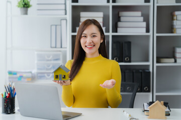 Smart Home Presentation: A focused person in a bright room is smiling and presenting a miniature...