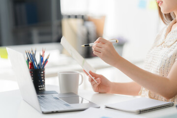 Focused Work: A focused individual, illuminated by sunlight, meticulously analyzes documentation,...