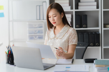 Focused Professional in Office: A diligent professional is engrossed in work, attentively reviewing...