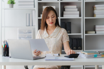 Focused Businesswoman in Office: A focused businesswoman engrossed in work, diligently reviewing...