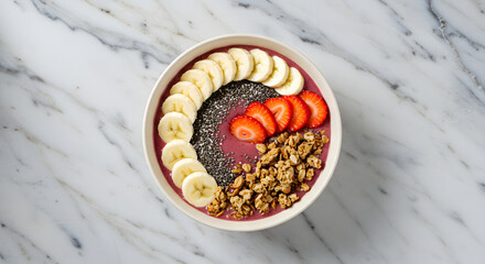 Overhead view of a vibrant smoothie bowl, artfully arranged with fresh fruit and granola.