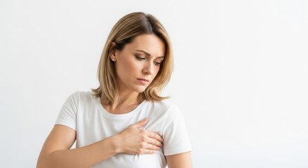 Concerned woman touching chest in white shirt - concept of health, self care, awareness