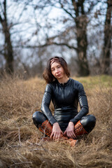 Girl in a field wearing a leather jumpsuit. Catsuit