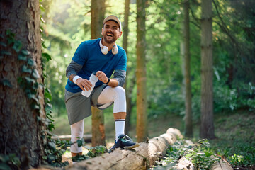 Happy athlete with water bottle in nature looking away.
