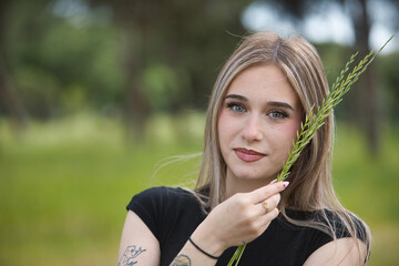 Portrait of a young woman, beautiful, blonde, green eyes, wearing a black t-shirt, sweet and...