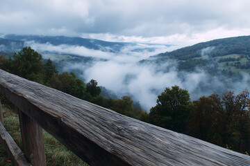 Weathered wooden railing overlooking misty mountain valley misty valley mountain landscape