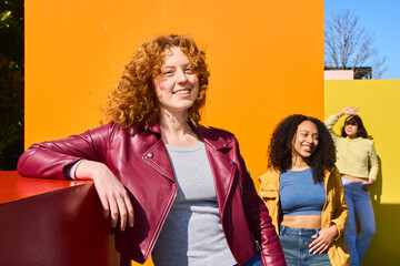 Young women smiling and having fun against colorful background