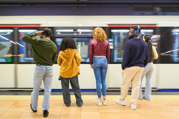 Fototapeta premium Young people waiting for arriving train in subway station