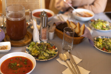 On the table is a plate of red borscht and cucumber salad