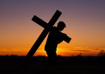 A silhouetted man carries a large wooden cross on his shoulders against a vibrant sunset sky