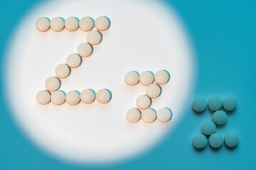 White pills in Z shape on blue background. Sleeping pills, hypnotic drugs, sedative