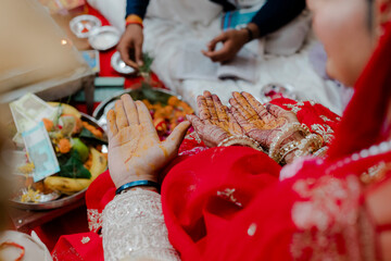 Wedding rituals in progress, hands adorned with intricate designs, symbolic of love and tradition,...