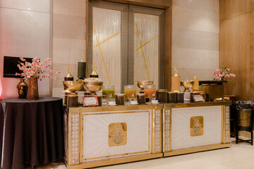Elegant refreshment setup with golden accents. A variety of juices and snacks are displayed on a...