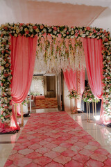 Floral-draped entryway with soft pink curtains and a patterned runner, setting a romantic and...
