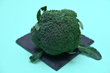 fresh head of broccoli cabbage on black board on green background