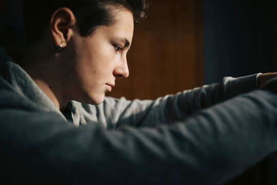Contemplative young man sitting with face down at home