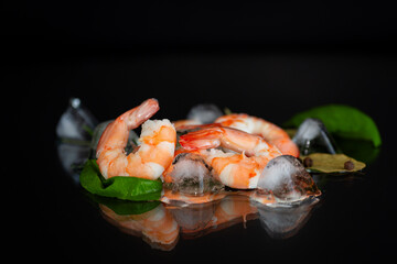 Shrimp with lemon, garlic and ice on a dark surface