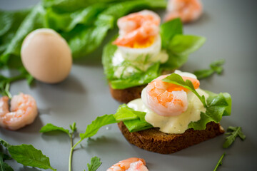 Appetizing breakfast with shrimp, egg and greens