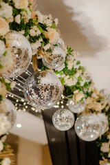 Elegant archway adorned with disco balls and flowers, creating a whimsical and celebratory atmosphere. Perfect for parties and weddings.