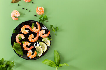 Appetizing boiled shrimps with lemon isolated on green background