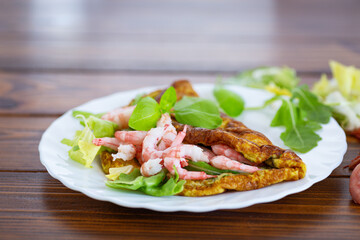 Delicious omelette with shrimps and fresh greens on top