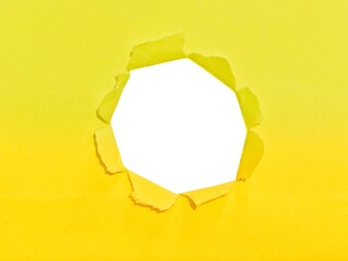 Torn hole on yellow paper on smooth white background. Sheet of yellow torn paper with blank space for text. Torn ripped recycle for advertising content promotion and advertising design.