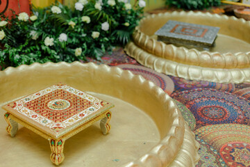 Ornate table and tray arrangement. Gold and red table sits on large gold tray. Colorful rug with...