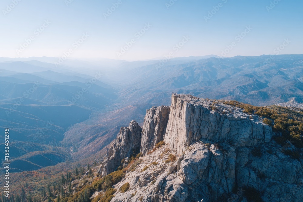 Poster drone-style top-down view of multiple hikers pausing at summit rock with backpacks
