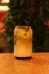 Matcha with strawberry puree, milk and ice. Refreshing sweet drink in a glass with a straw. Close-up of matcha. Drink on a table in a cafe or restaurant. Glass of strawberry green tea