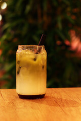 Matcha with strawberry puree, milk and ice. Refreshing sweet drink in a glass with a straw. Close-up of matcha. Drink on a table in a cafe or restaurant. Glass of strawberry green tea