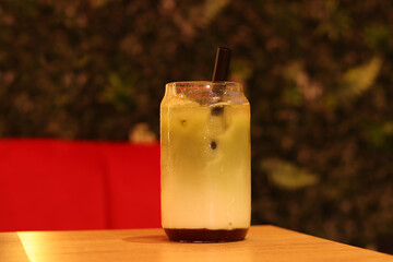 Matcha with strawberry puree, milk and ice. Refreshing sweet drink in a glass with a straw....