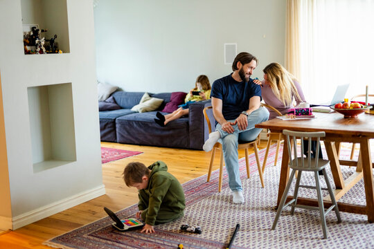 Family spending leisure time in living room at home