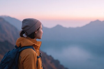 portrait of solo hiker with trekking poles at summit of mount rinjani overlooking crater lake