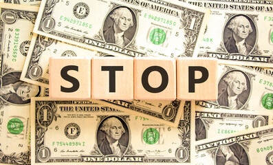 Stop symbol. Concept word Stop on beautiful wooden blocks. Dollar bills. Beautiful background from...