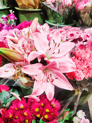 Flower bouquet with pink lilies and mixed red flowers.