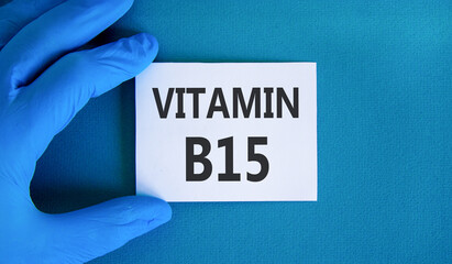 Vitamin B15 pantothenic acid symbol. Concept words Vitamin B15 on beautiful white card. Doctor's hand in blue medical glove. Beautiful blue background. Medical healthy lifestyle Vitamin B15 concept.