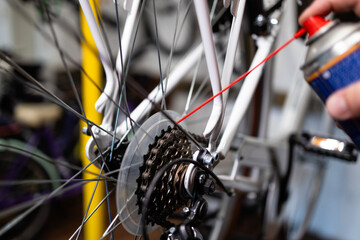 Close up view of chain and gear shifter lubrication in bicycle service workshop.