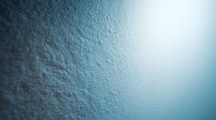 Close up macro texture of fine blue snow crystals with bright light on the right